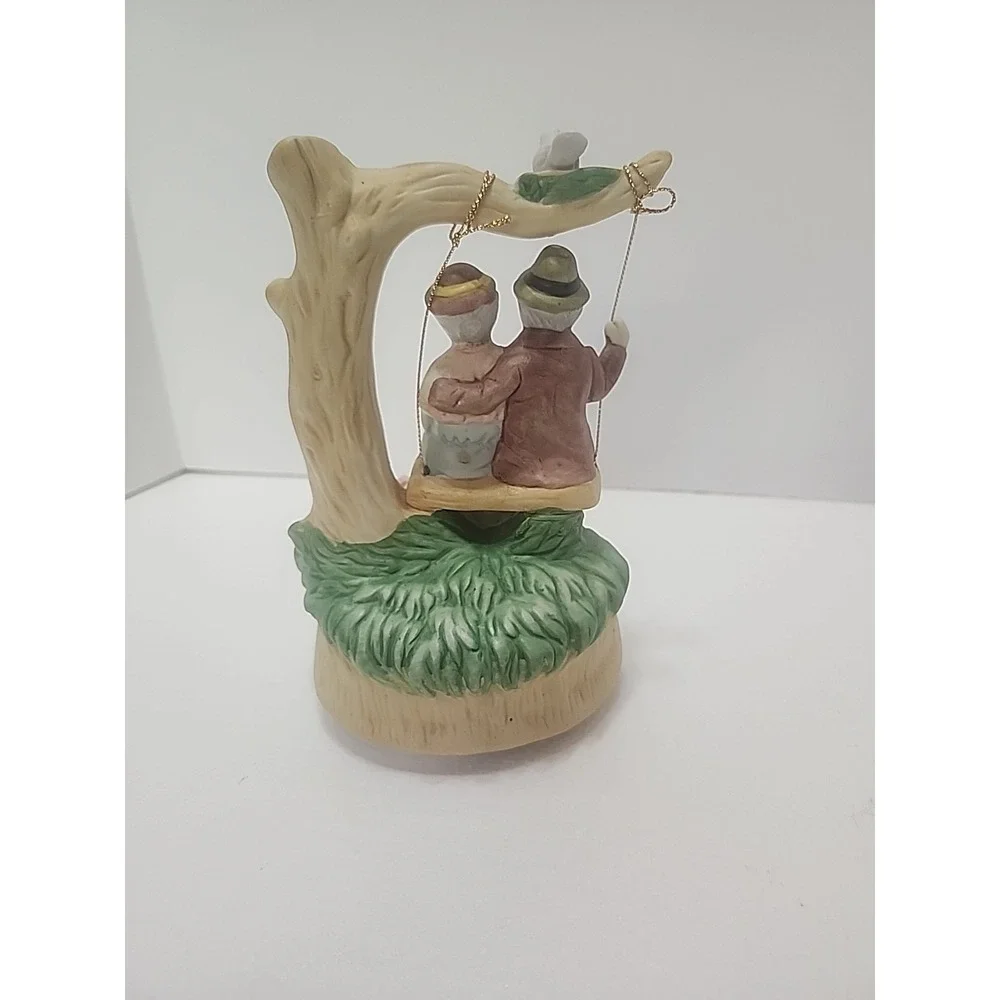 MSR Imports Inc. Porcelain Music Box Elderly Couple on Swing. Writing On Bottom